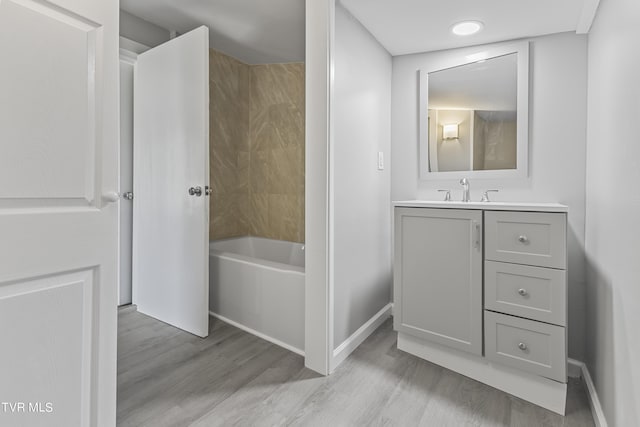 bathroom featuring shower / bathtub combination, vanity, and wood-type flooring