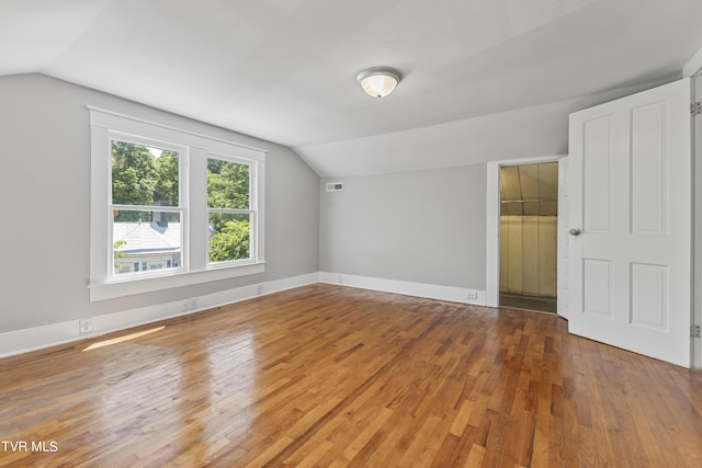 additional living space featuring hardwood / wood-style flooring and lofted ceiling