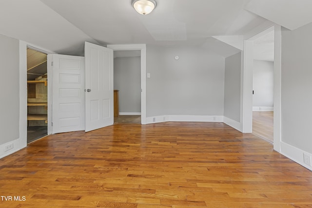 bonus room with lofted ceiling and light hardwood / wood-style floors