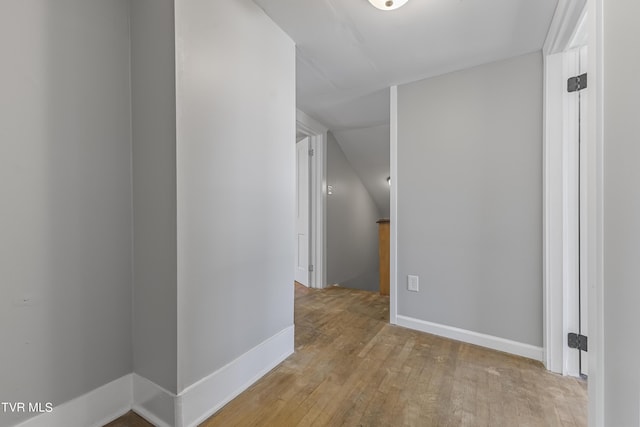 hallway featuring lofted ceiling and light wood-type flooring