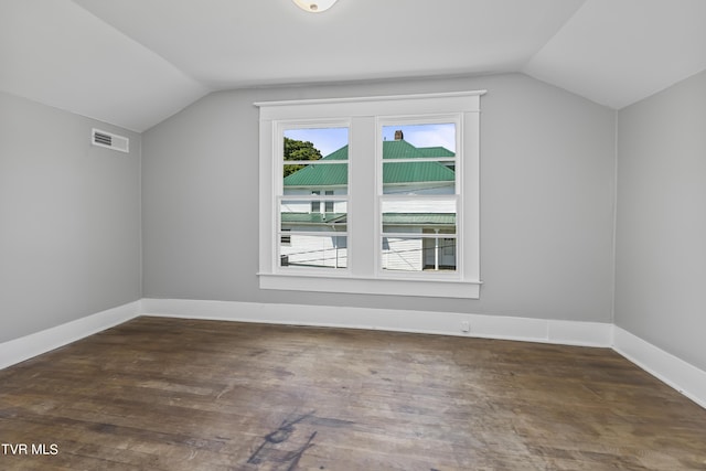 additional living space featuring vaulted ceiling and dark hardwood / wood-style floors