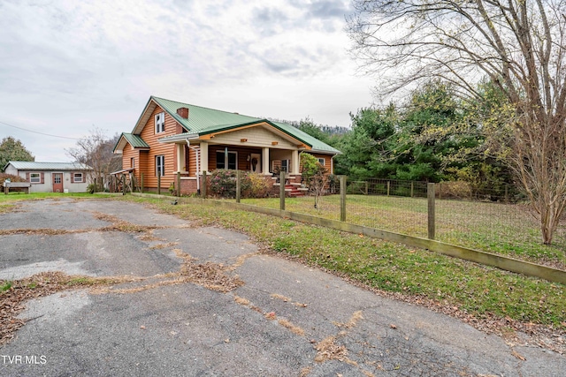 bungalow-style home with covered porch and a front lawn