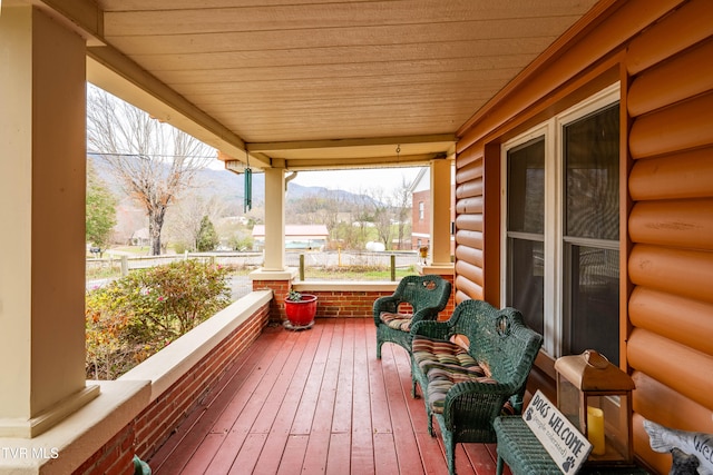 wooden terrace with a mountain view and a porch