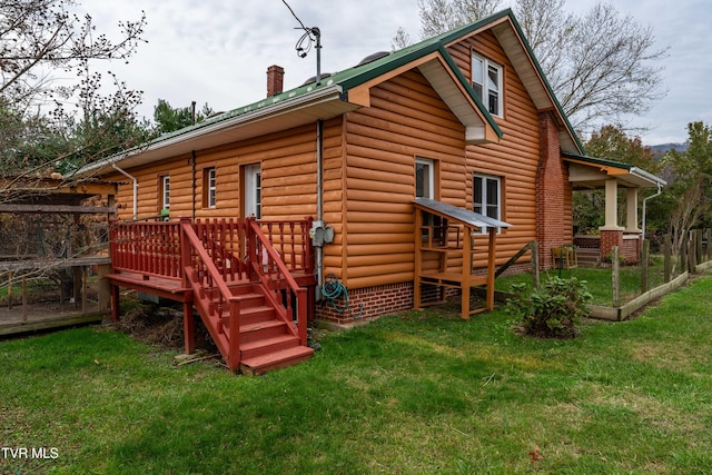 rear view of house with a wooden deck and a yard