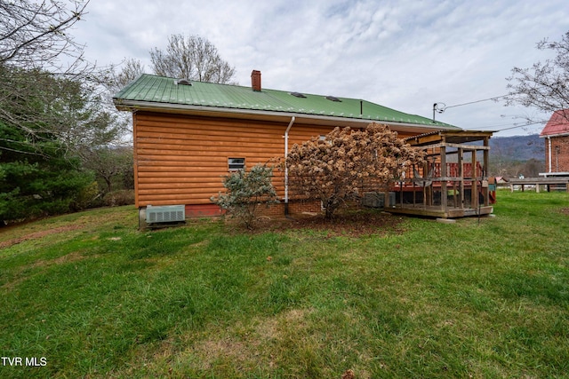 back of property with a deck and a lawn