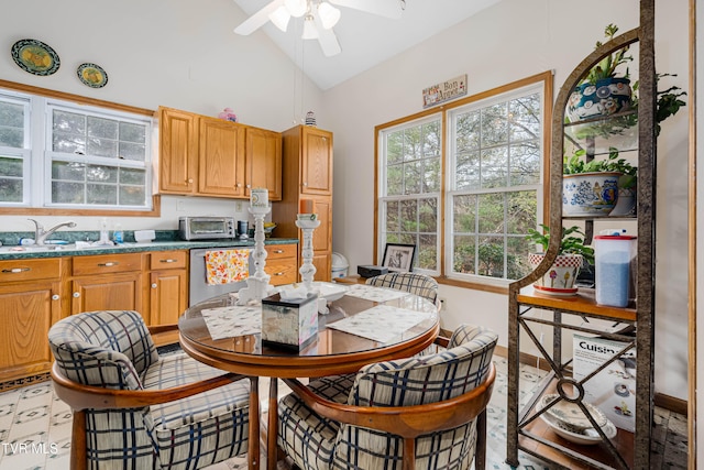 dining space with ceiling fan, sink, and lofted ceiling