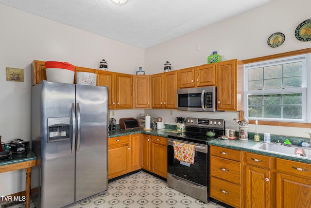 kitchen with sink, stainless steel appliances, and a textured ceiling