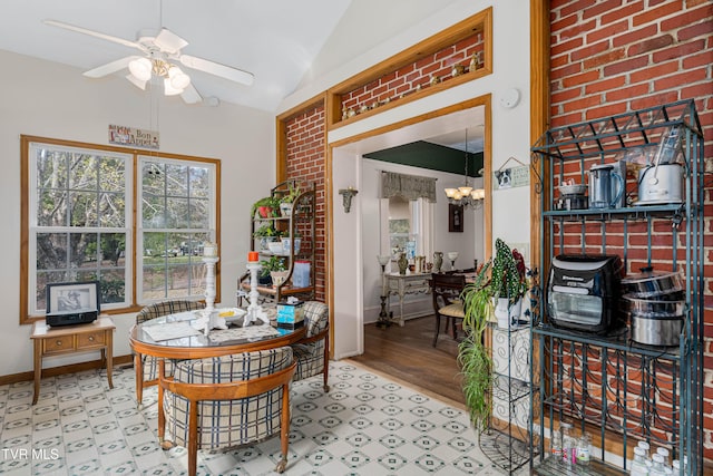 dining space featuring ceiling fan with notable chandelier, hardwood / wood-style flooring, and lofted ceiling