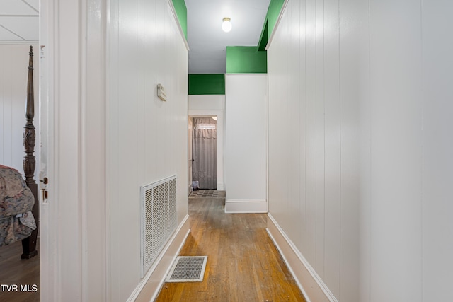 hall featuring hardwood / wood-style floors and wood walls