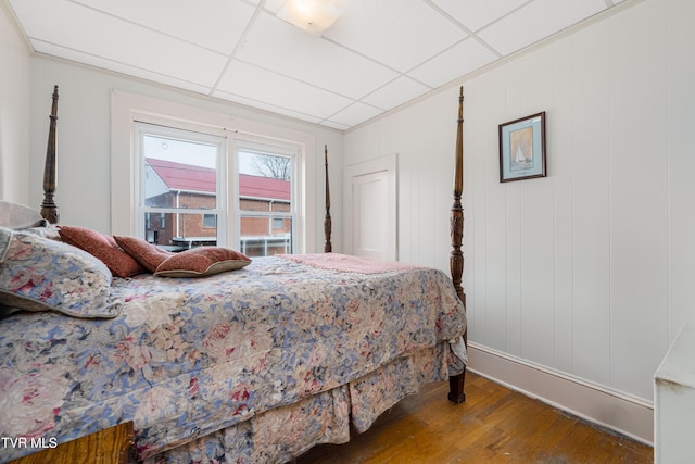 bedroom featuring wood-type flooring and a paneled ceiling