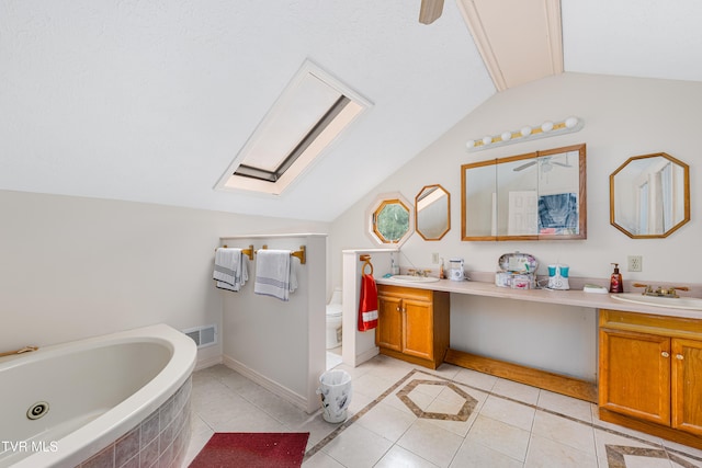 bathroom with tile patterned flooring, vanity, a relaxing tiled tub, and lofted ceiling with skylight