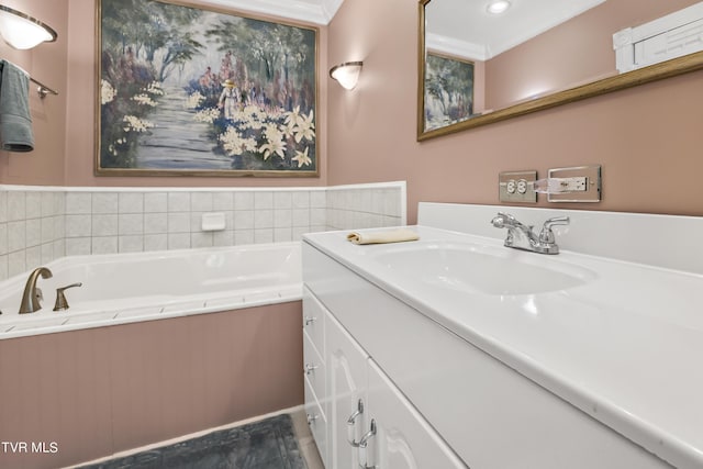 bathroom with vanity, a bathtub, and ornamental molding