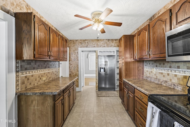 kitchen with decorative backsplash, ceiling fan, a textured ceiling, and appliances with stainless steel finishes