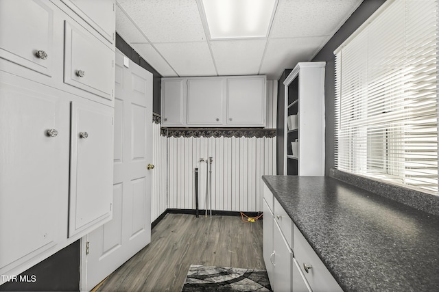 kitchen with a paneled ceiling, dark hardwood / wood-style floors, and white cabinets