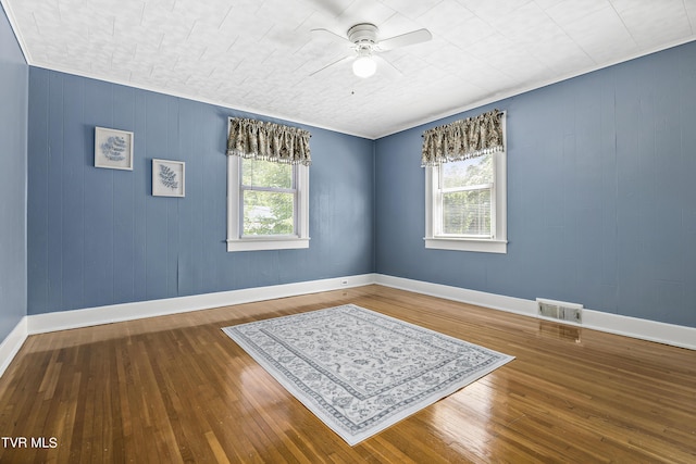 unfurnished room featuring hardwood / wood-style flooring, ceiling fan, and a wealth of natural light