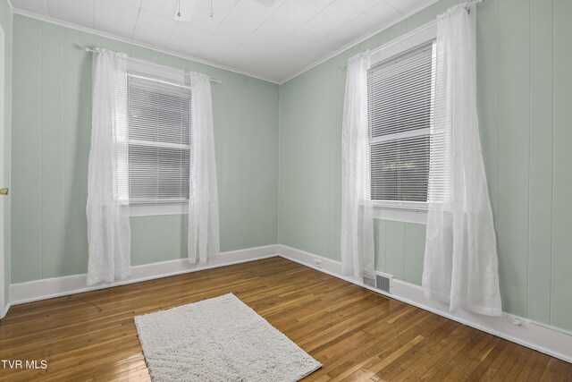 spare room featuring crown molding and hardwood / wood-style flooring