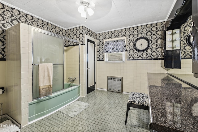 bathroom with crown molding, enclosed tub / shower combo, tile walls, and heating unit