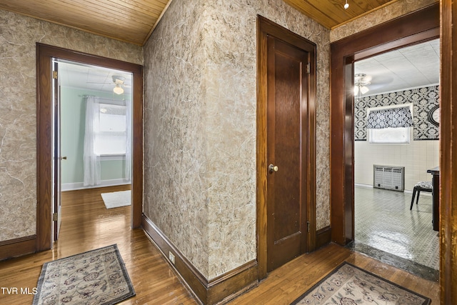 hallway featuring hardwood / wood-style floors, crown molding, and wood ceiling