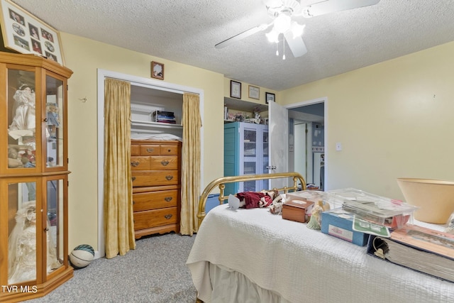 carpeted bedroom with ceiling fan and a textured ceiling