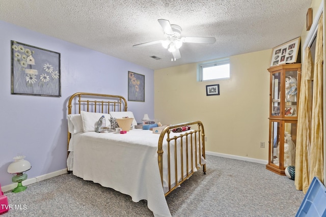 bedroom with ceiling fan, carpet floors, and a textured ceiling