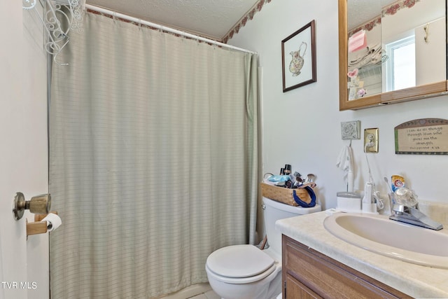 bathroom with vanity, a textured ceiling, and toilet