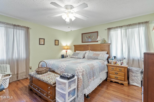 bedroom featuring wood-type flooring, ceiling fan, and a textured ceiling