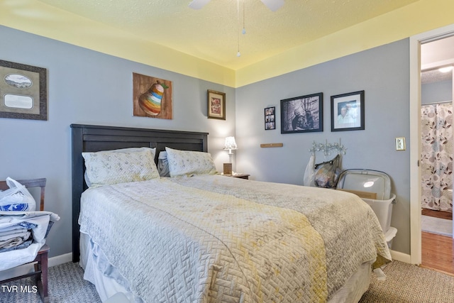 carpeted bedroom with ceiling fan and a textured ceiling