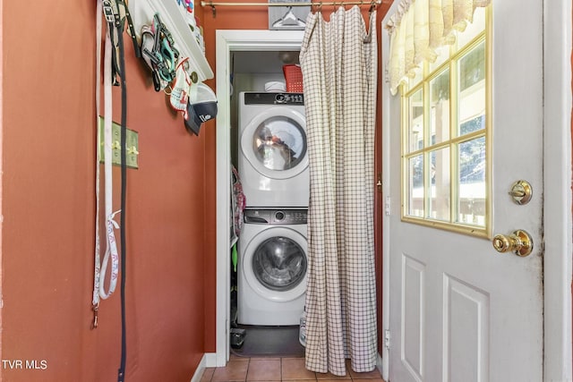 washroom featuring stacked washing maching and dryer and light tile patterned floors