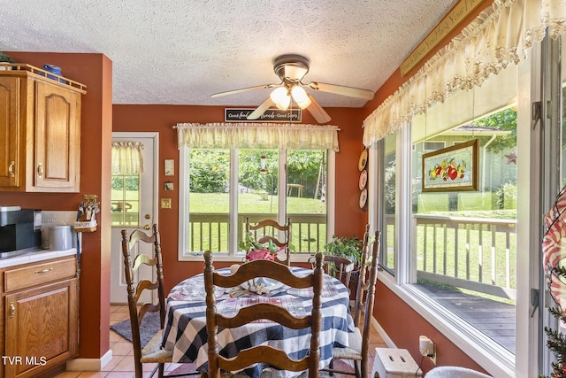 dining area featuring light tile patterned floors, a textured ceiling, and ceiling fan