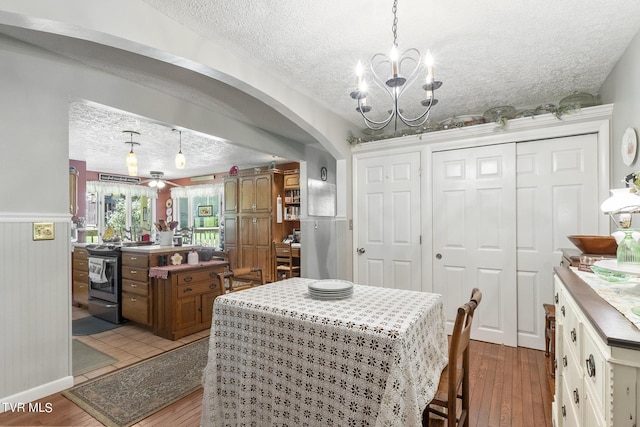 dining space with a chandelier, a textured ceiling, and light hardwood / wood-style flooring