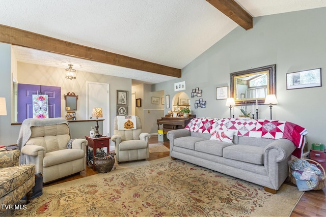 living room featuring hardwood / wood-style floors, lofted ceiling with beams, and a textured ceiling