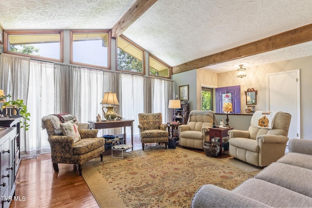 living room with plenty of natural light, beam ceiling, and wood-type flooring