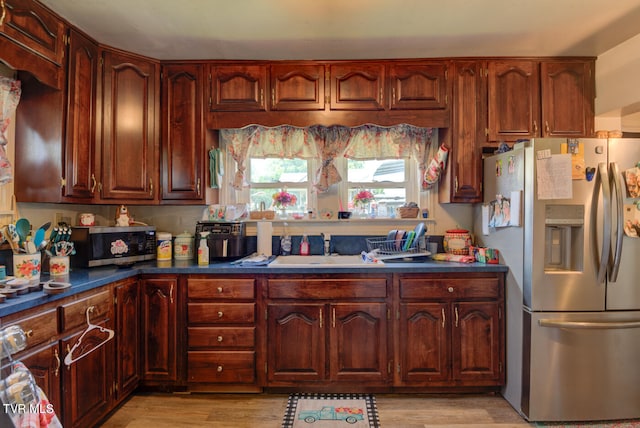 kitchen with stainless steel appliances, light hardwood / wood-style flooring, and sink