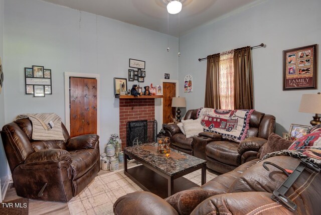 living room with ceiling fan and a brick fireplace