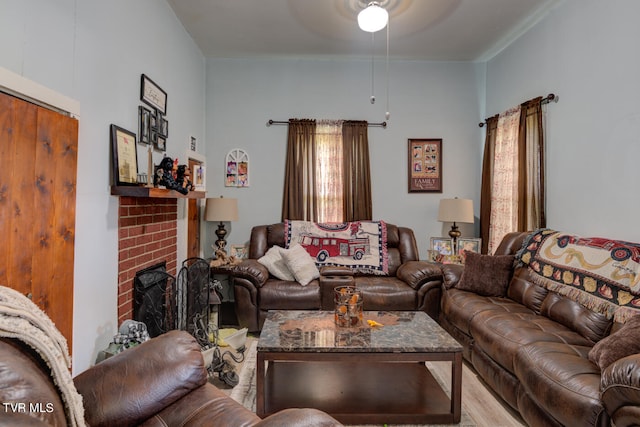 living room with plenty of natural light, ceiling fan, light hardwood / wood-style floors, and a brick fireplace