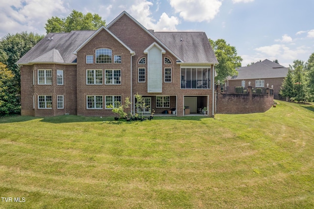 back of house featuring a yard and a sunroom