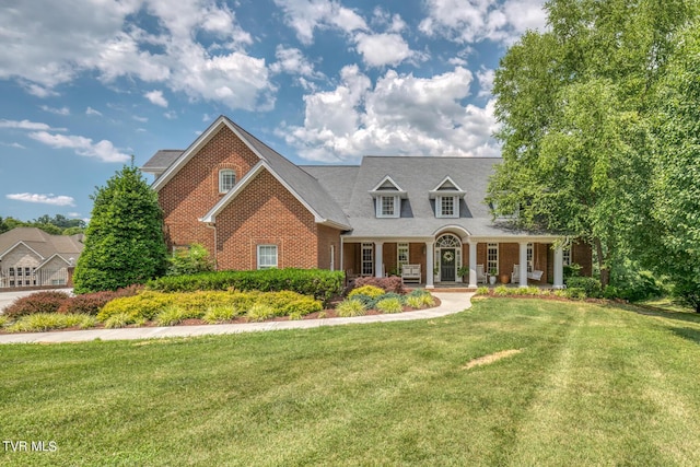 cape cod house featuring a front yard and covered porch