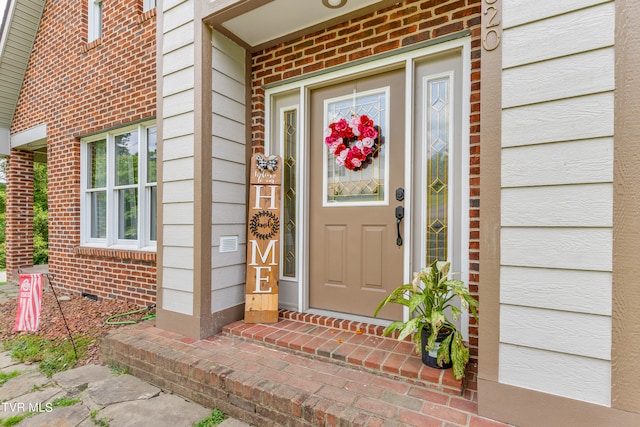 view of exterior entry with brick siding