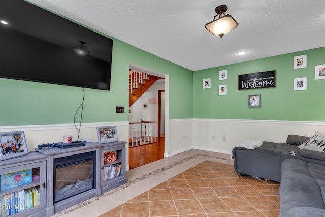 tiled living area featuring baseboards, recessed lighting, and a textured ceiling