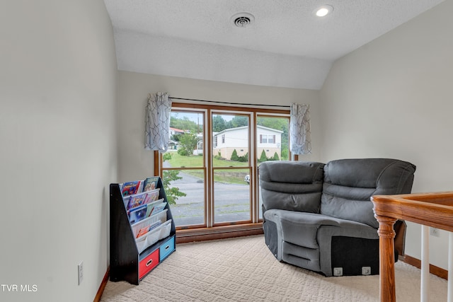 sitting room featuring light carpet, visible vents, vaulted ceiling, and a healthy amount of sunlight