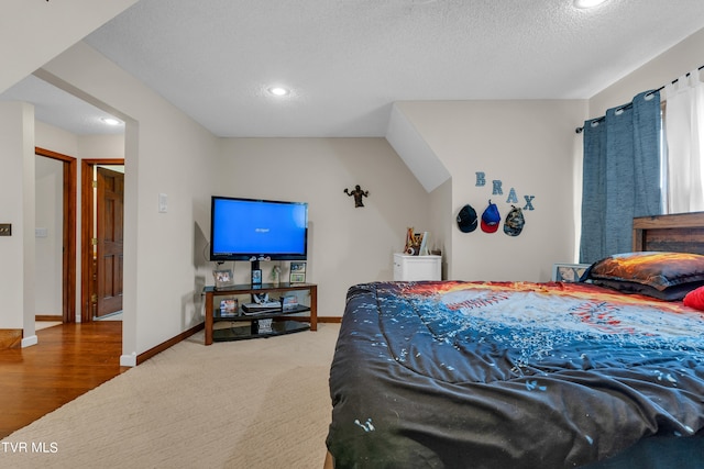 carpeted bedroom with recessed lighting, baseboards, and a textured ceiling