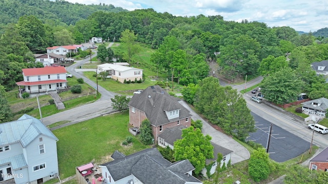 drone / aerial view featuring a wooded view and a residential view