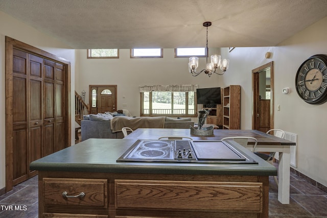 kitchen featuring pendant lighting, a center island, a chandelier, and a textured ceiling