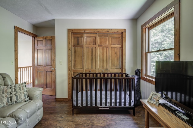 bedroom featuring dark hardwood / wood-style flooring and a textured ceiling