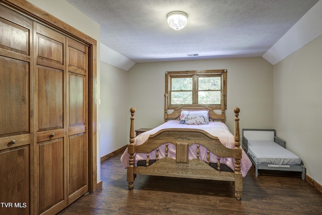 bedroom featuring a textured ceiling, dark hardwood / wood-style floors, a closet, and lofted ceiling