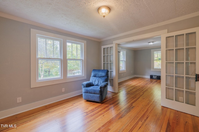 unfurnished room with ornamental molding, a textured ceiling, and hardwood / wood-style floors