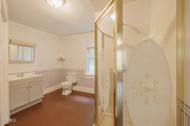 bathroom with vanity, a textured ceiling, ornamental molding, toilet, and an enclosed shower