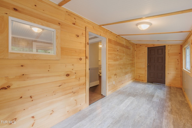 spare room with wooden walls and hardwood / wood-style floors