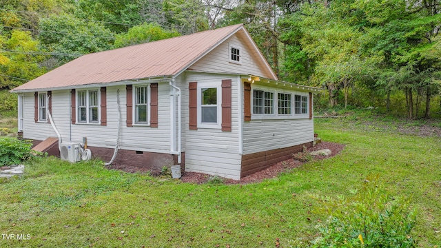 view of front of property with a front yard and ac unit