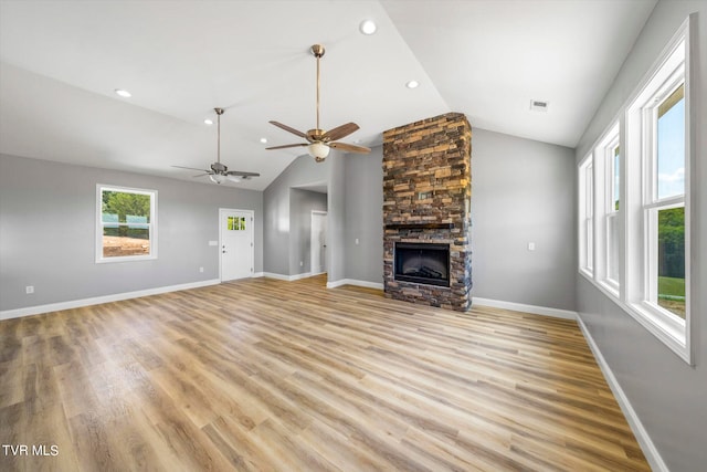 unfurnished living room featuring light hardwood / wood-style flooring, vaulted ceiling, ceiling fan, and a fireplace